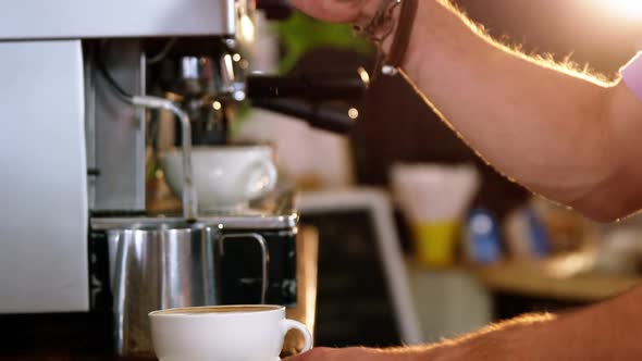 Waiter making cup of coffee