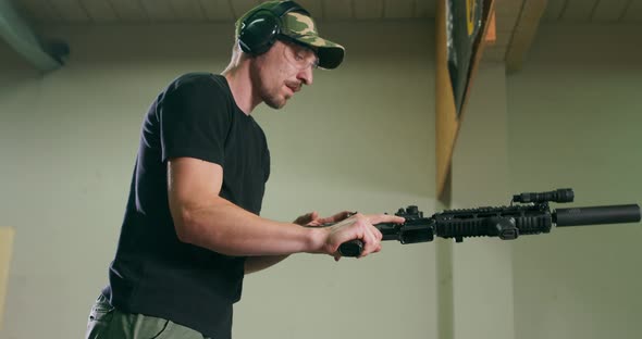 A Man Wearing Goggles and Ear Protection Unloads a Long Gun By Removing the Magazine Clip and