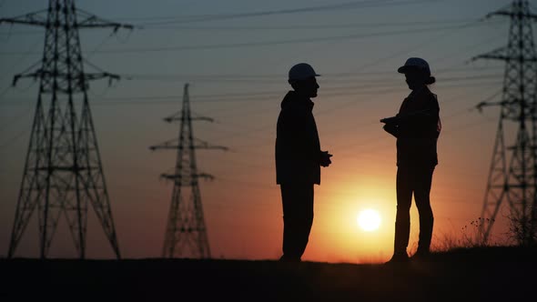 Team of Engineers in Protective Helmets with Laptop in Hands Discuss Energy Efficiency and