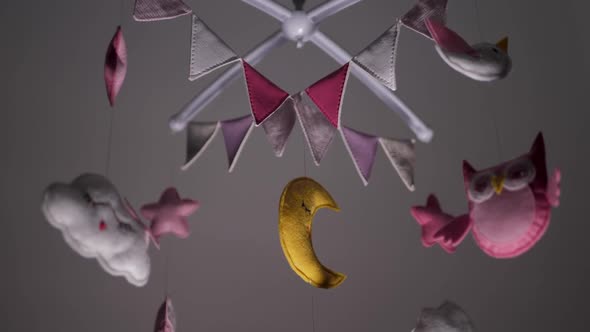 Baby Mobile with Pink Handstitched Animal and Bird Toys with Yellow Moon on White Wall Background