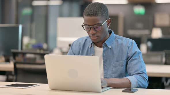 Young African American Man Smiling at Camera at Work