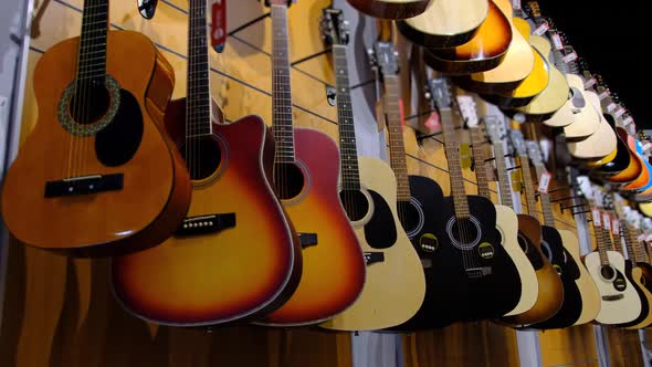 Guitar Shop. Lots of New Multicolored Acoustic Guitars Are Hung in Music Store