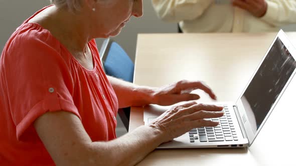 Senior man and woman using laptop and digital tablet