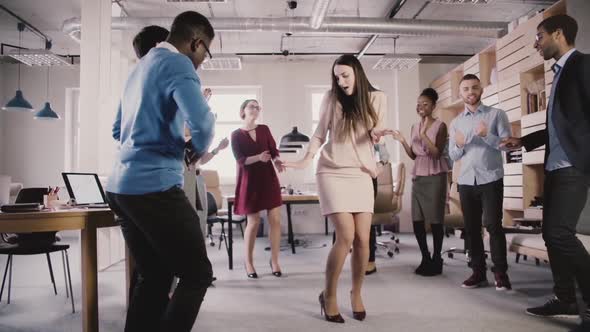 Happy CEO Businesswoman Celebrating Corporate Achievement with a Dance at Casual Multiethnic Office