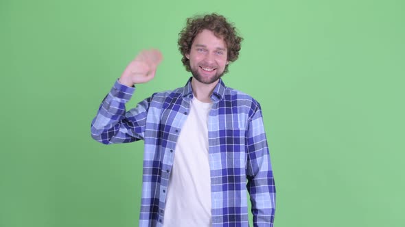 Happy Young Bearded Hipster Man Waving Hand