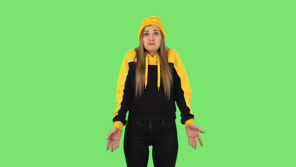 Modern Girl in Yellow Hat Upset Is Shrugging and Sighing. Green Screen