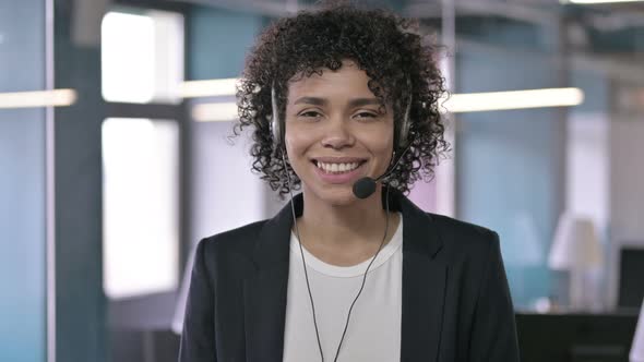 Portrait of Cheerful African Businesswoman Listening Through Head Phones