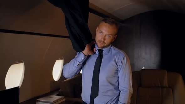 Entrepreneur Throwing a Jacket on His Shoulder in Private Jet.