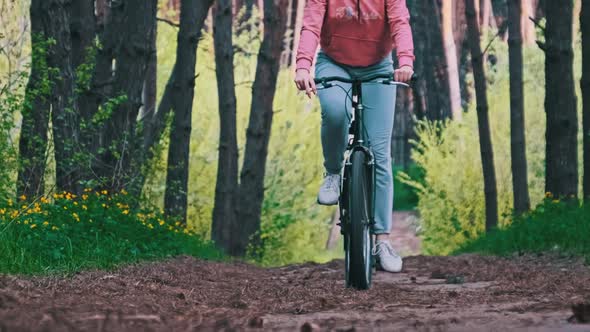 Young Woman on a Bicycle Rides Along a Forest Path in Summer Day Slow Motion