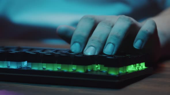 Gamer Typing on Backlight Keyboard Closeup Man Playing Video Game