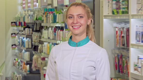 Cheerful Female Pharmacist Crossing Her Arms, Posing Proudly at Her Drugstore