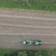 An Aerial View Shot By a Drone of the Tractor Harvesting Grass and Packaging It Into Neat White - VideoHive Item for Sale