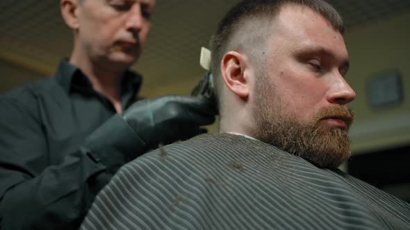 Barber Trimming Hair of Bearded Man
