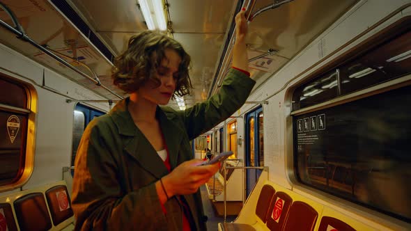 Young Millennial Woman with Smartphone in Subway