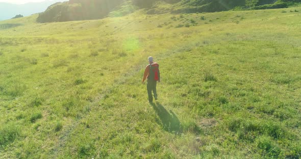 Flight Over Backpack Hiking Tourist Walking Across Green Mountain Field