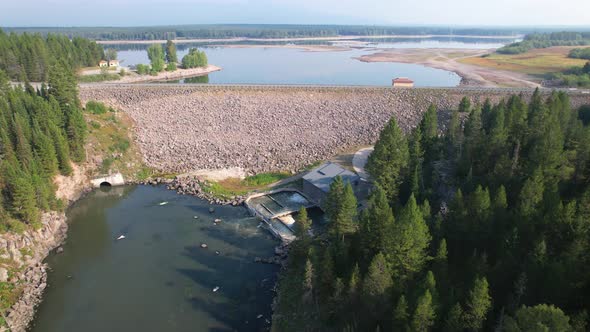 Beautiful aerial view of a dam and lake in Island park Idaho.  Also seeing a wide of a small hydroel