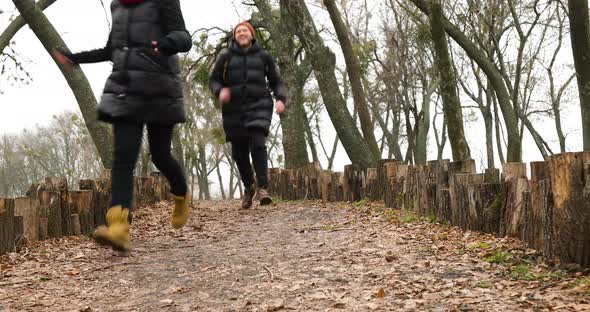 Couple travelers running, happy, catching up in the wood