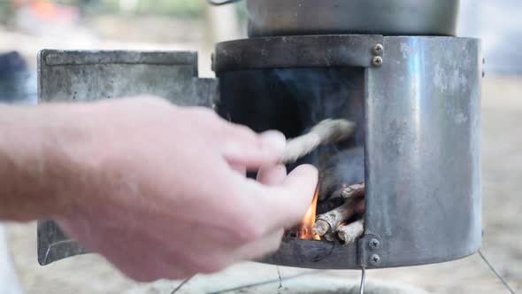 Putting firewood into stove