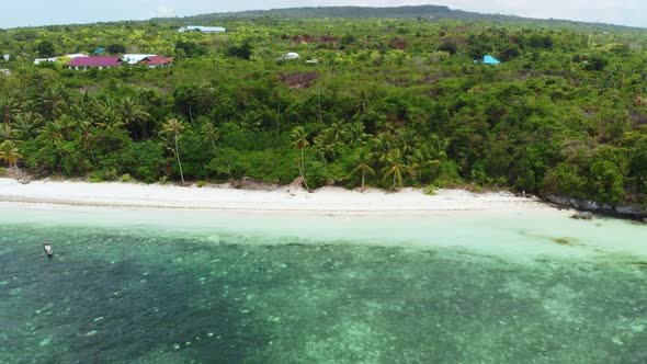 Aerial: Flying over tropical beach turquoise water coral reef, Indonesia