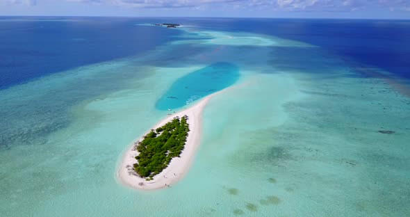 Wide flying clean view of a sandy white paradise beach and aqua blue water background in colorful 4K