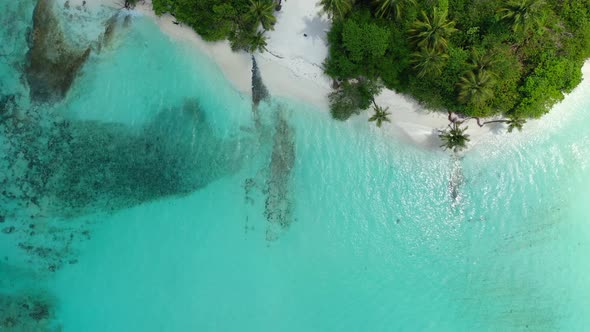 Wide angle drone abstract view of a white sand paradise beach and blue water background in 4K