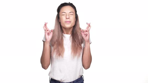 Portrait of Cute Woman with Dyed Hair Keeping Fingers Crossed and Palms Together While Wishing for