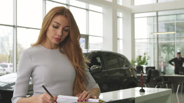 Gorgeous Woman Buying a New Car at the Dealership Smiling To the Camera