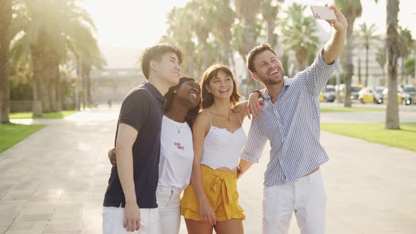 Cheerful Multiracial Friends Making Selfie While Spending Summer Vacation Together on Seashore