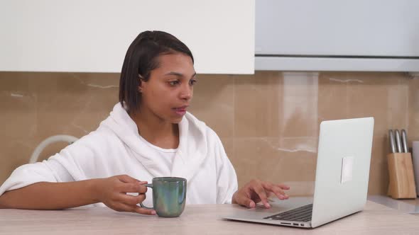 Young Beautiful African American Woman Working Online at Home with a Laptop