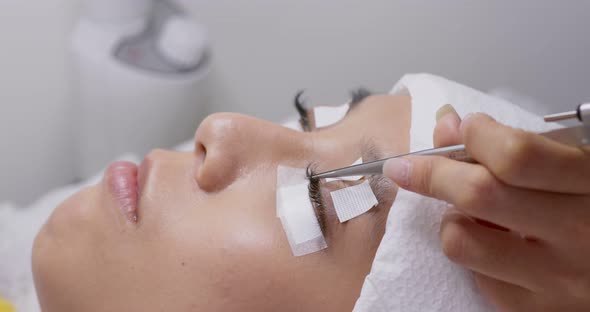 Woman having eye lash extension process