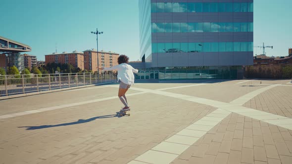 Beautiful young woman cruising around the city with her longboard.