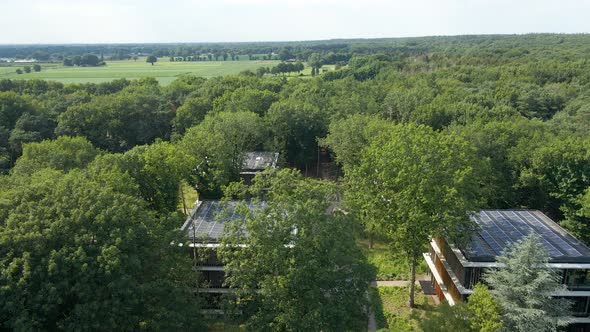 Jib up of small offices with solar panels on rooftop in an insirational green forest environment