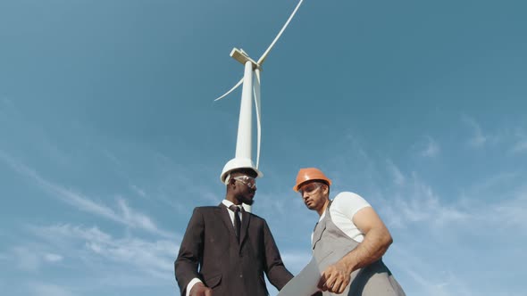 Team of Businessman and Engineers in a Black Suit Walking Explores Future Wind