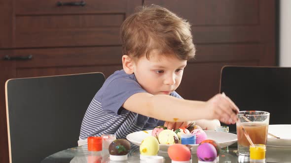 Easter Celebration Concept. Happy Little Boy Decorating Easter Eggs for Holiday