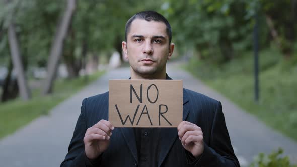 Serious Strong Caucasian Adult Man Activist Standing Outdoors Demonstrating Cardboard Plate with