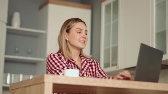 Smiling blonde woman working on laptop