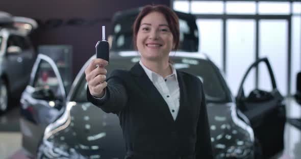 Close-up of Positive Caucasian Woman Showing Car Keys at Camera. Focus Changes From Face of Female