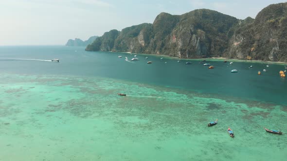 Busy Harbour in Tonsai Bay with Long-tail boats and small yachts moored in Ko Phi Phi, Thailand