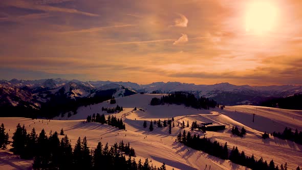 Picturesque white mountain slopes covered with pine forests and skiing pistes anding chairlift in ea