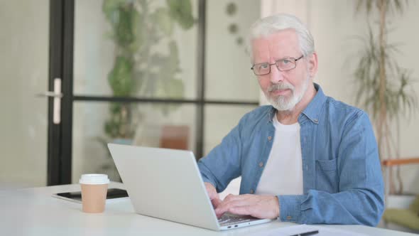 Senior Old Man Showing Thumbs Up While Using Laptop in Office