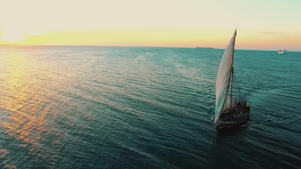 fishermen's wooden dhow sailing at sunset in Zanzibar