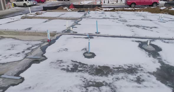 A construction site with a concrete pad fully plumbed out.