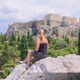 Female tourist sitting at Areopagus Hill that looks onto the Acropolis in Athens, Greece - VideoHive Item for Sale