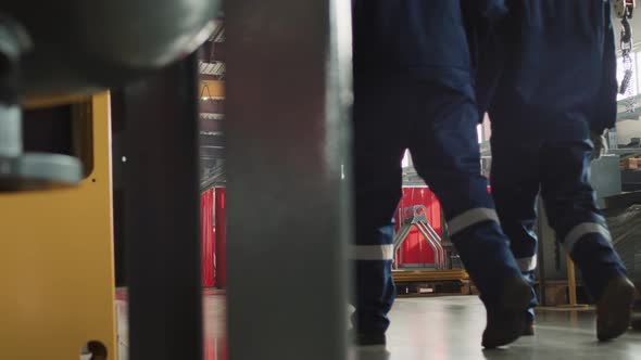 Rear View Of Workers Walking Through Plant Facility