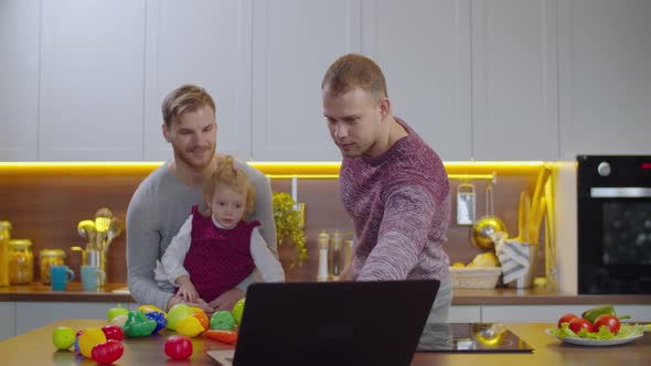 Gay Parents and Child Watching Educational Program