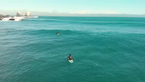 Aerial drone shot flying above surfers on a sunny day in Pichilemu, Chile-4K