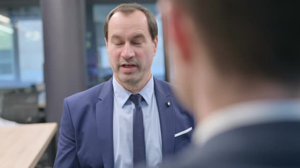 Rear View of Businessman Talking to Colleague