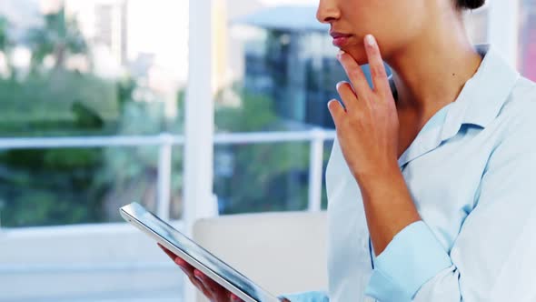 Serious woman using tablet computer then laughing