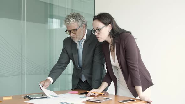 Female Manager Explaining Reports To Male Boss