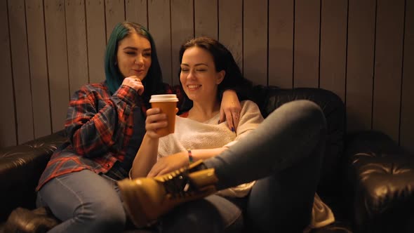 Cute Lesbian Couple Drinking Coffee and Chatting in Cafe